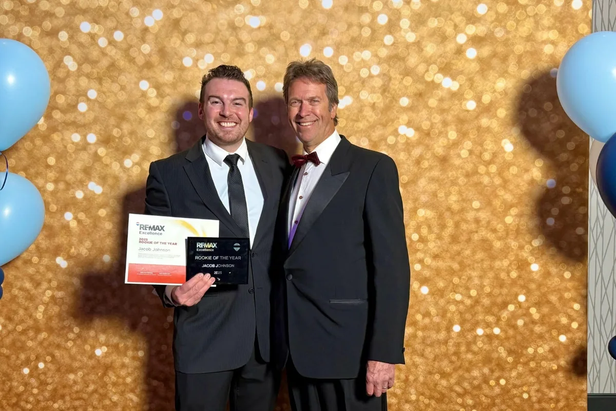 Jacob Johnson holding his RE/MAX Excellence award at the awards gala